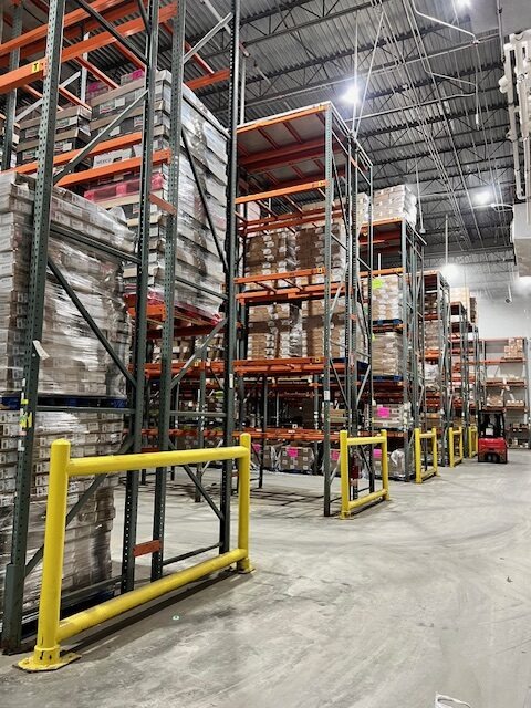 Warehouse interior showcasing tall shelving units filled with stacked boxes, highlighting organized storage and inventory management.